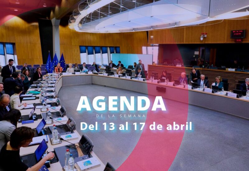 Reuni&oacute;n en una sala con participantes y pantallas de presentaci&oacute;n