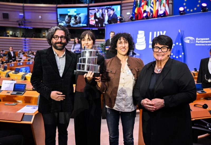 Cuatro personas sosteniendo un trofeo en el Parlamento Europeo