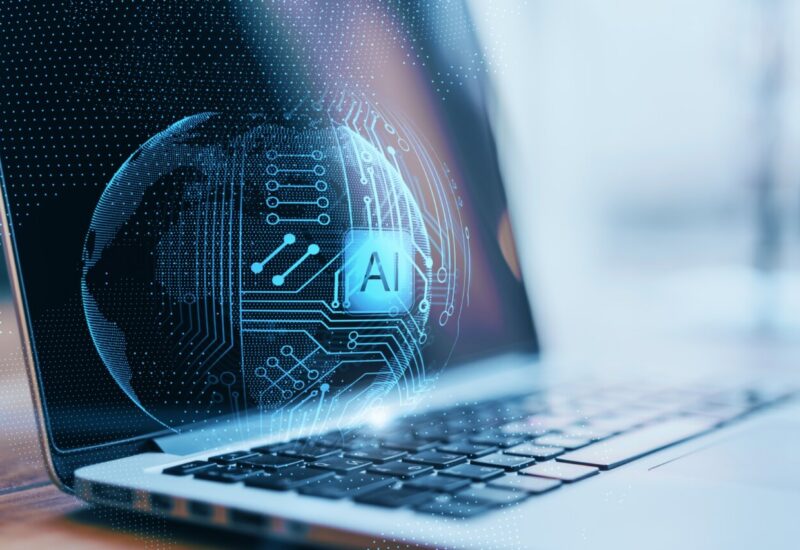 Primer plano de un laptop con esfera abstracta de inteligencia artificial.