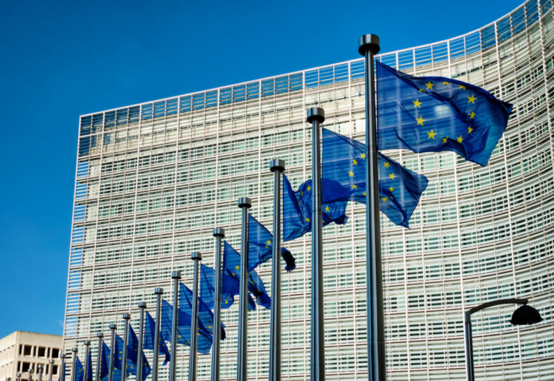 Banderas de la Uni&oacute;n Europea ondeando frente a un edificio moderno