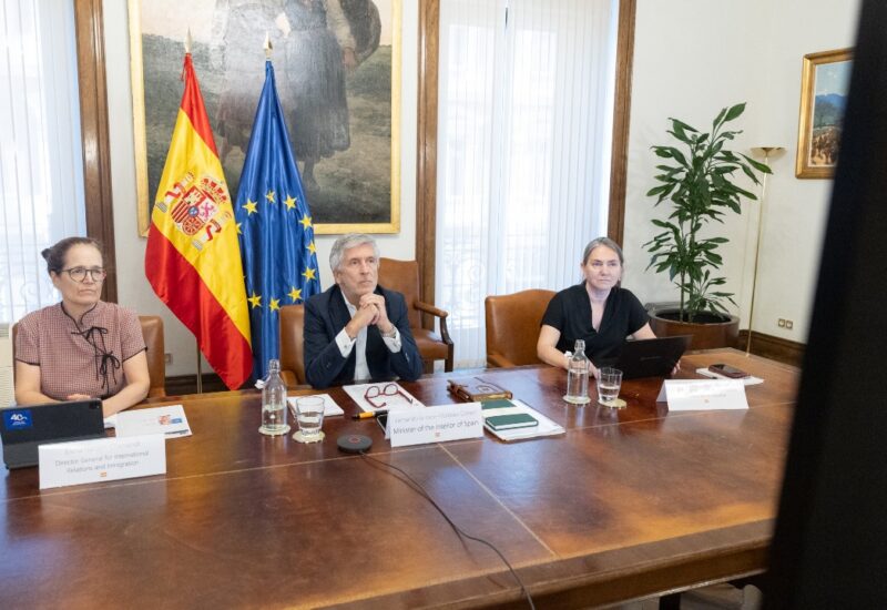 Ministro del Interior de España en reunión con banderas de España y UE